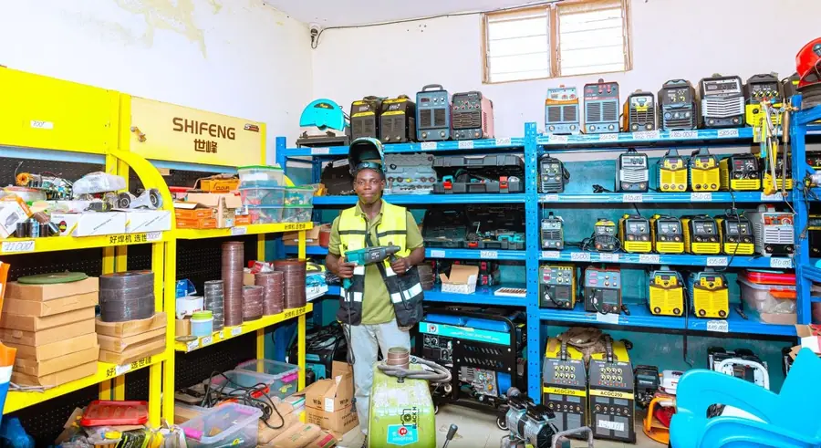 Un conseiller ECYT présente un outil électrique dans la boutique